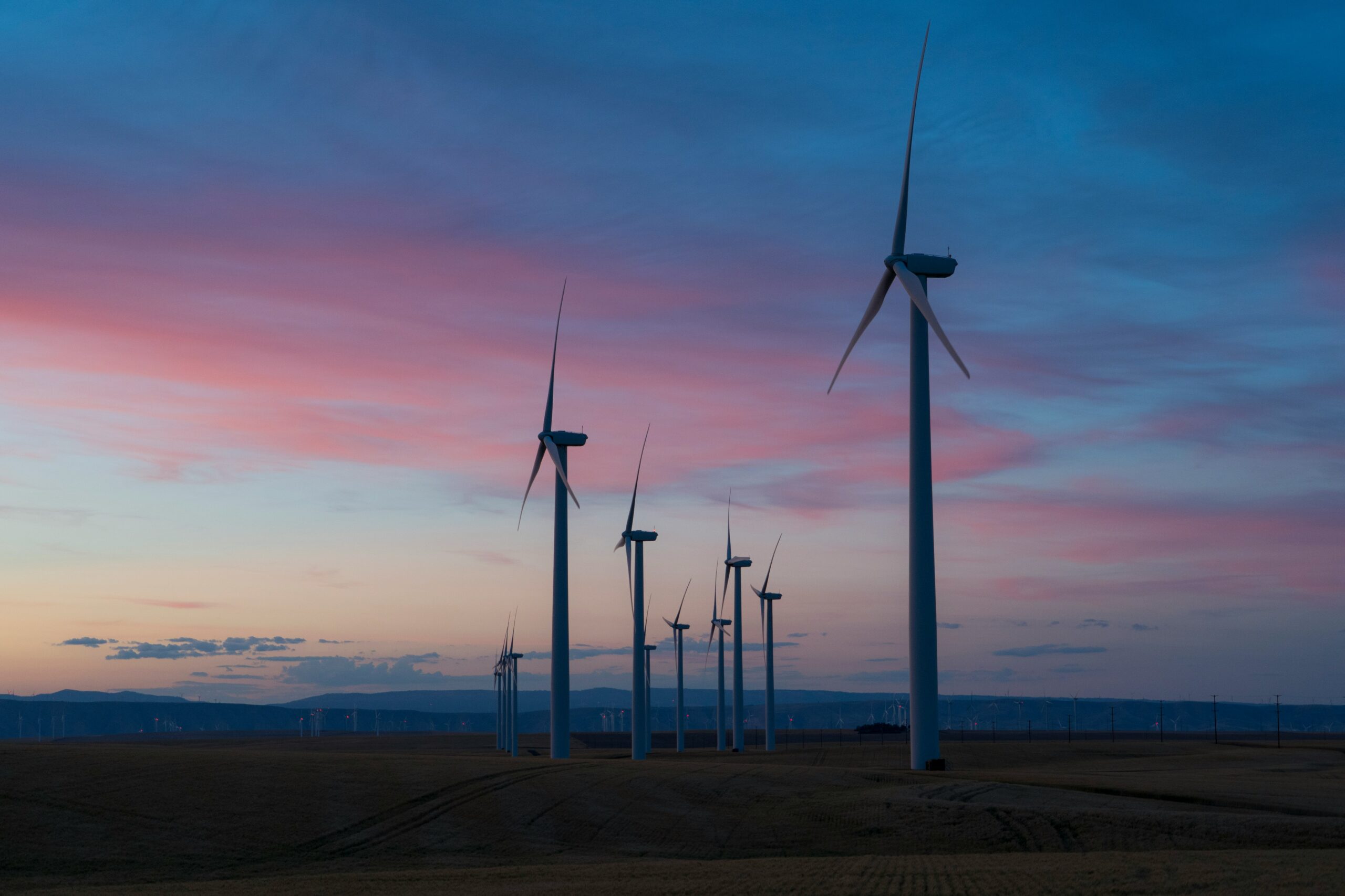 Wind turbines dot the landscape in a purple evening